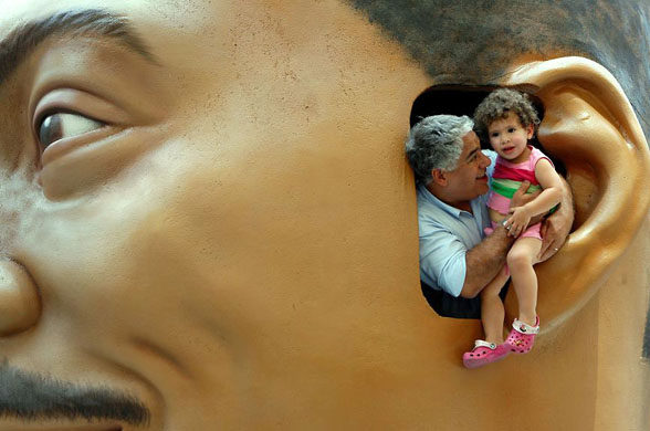 New York: Pedestrians pose for a picture in the ear of a large model of Eddie Murphy's head in Times Square