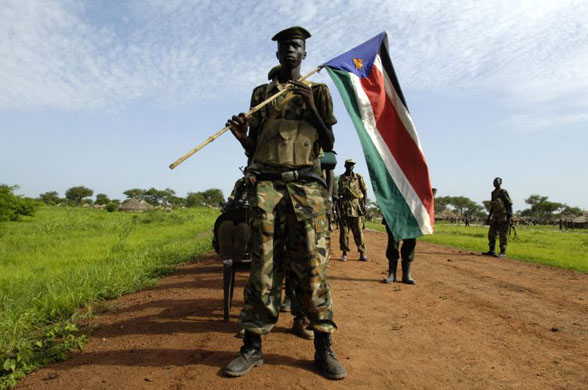 Abyei, Sudan: A Sudan People's Liberation Army soldier carries the army's flag as they redeploy south, in line with the road map to resolve the Abyei crisis