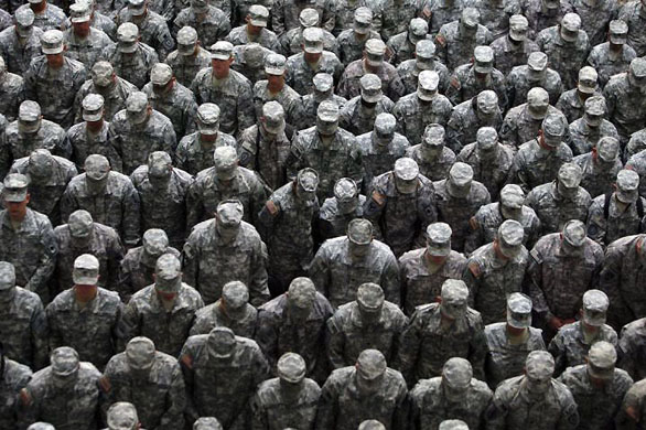 Baghdad, Iraq: US soldiers bow their head as they pray during a mass reenlistment ceremony