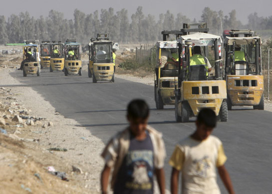 Gaza strip: Palestinian forklift trucks on their way to the Sufa border post to unload trucks carrying goods from Israel. Supplies have been arriving after Israel and Hamas agreed a truce three weeks ago. Photograph: Adel Hana/AP