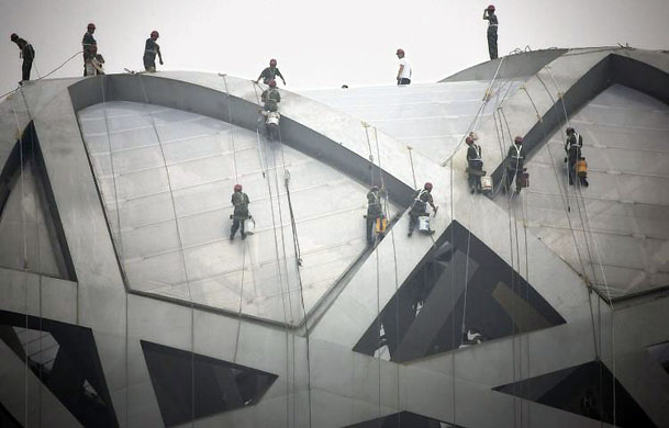 Beijing, China: Workers clean the top of the National Stadium