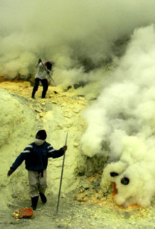 East Java province, Indonesia: Miners collect molten sulphur from the volcanic Kawah Ijen