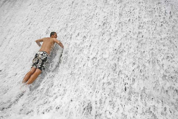 A man cools off in a waterfall