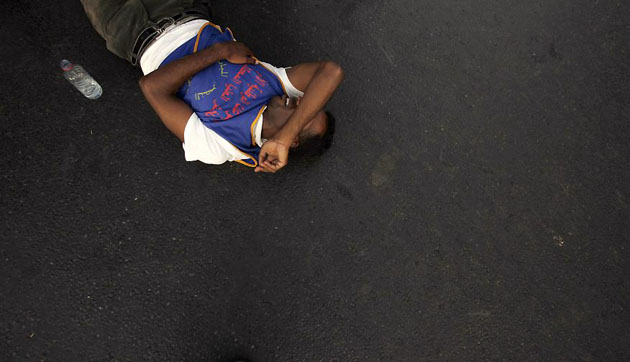 Rabat, Afghanistan: A man lies injured on the road during a protest demanding more public sector jobs