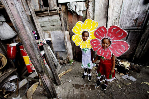 Santiago de Cuba, Cuba: Two girls wear butterfly costumes as they get ready to perform during the annual carnival