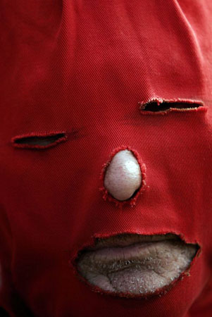 Emboscada, Paraguay: A man, wearing a mask, takes part in a procession honoring San Francisco Solano, patron of birds