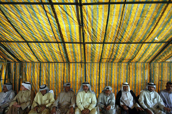Muqtadiyah, Iraq: Men sit under tent during a meeting of local tribe leaders and US soldiers