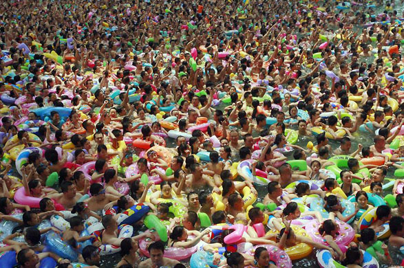 Suining, China: Local residents crowd a swimming pool during hot weather