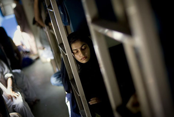 Pakistan: A woman sleeps as she travels on a train between Lahore and Rawalpindi