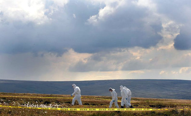 Meltham, UK: Forensic police search moorland near Saddleworth after a farmer walking his dog found bones