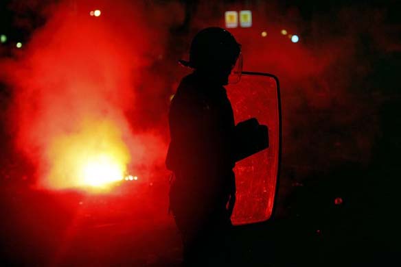 An anti-riot policeman stands in the street during clashes 