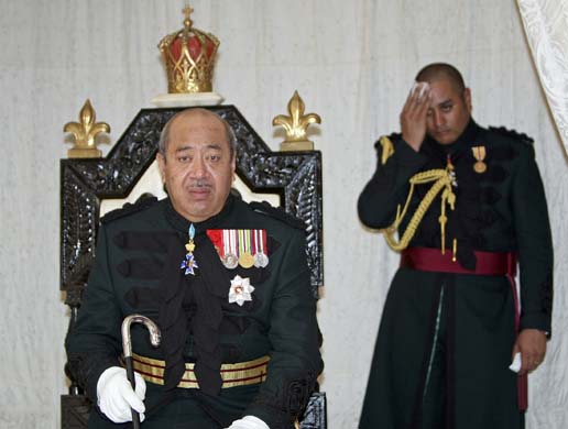 King George Tupou V, sits on his throne