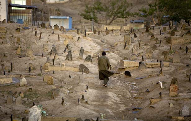 A young man makes his way through a Shiite cemetery in Kabul
