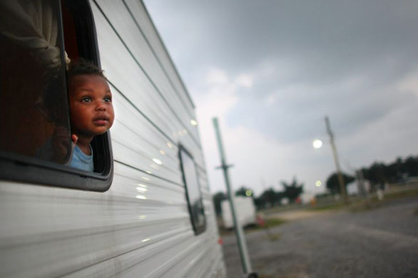 A child looks out of a trailer in the FEMA Diamond travel trailer park in Louisiana