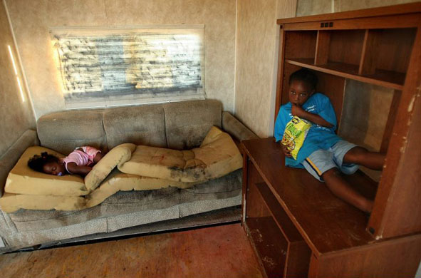 Kailah Smith, 18 months, sleeps on a moldy couch caused by rain leaks in her parents' trailer in Louisiana