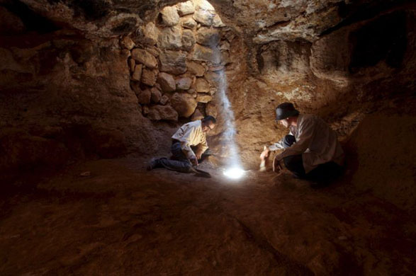 two archeologists work inside ethe cave under the church in the town of Rehab 