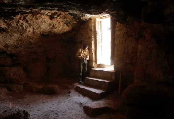 A Jordanian archeologist stand by the entrance of the cave 