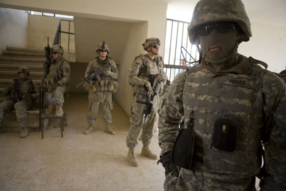 American troops from the 101st Airborne Division and an Iraqi interpreter (R masked) search a school in a Shia area of Baghdad 