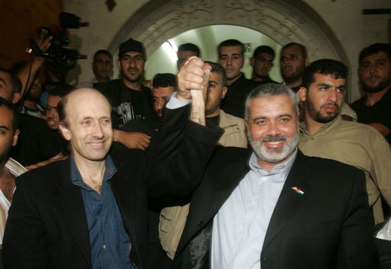 BBC reporter Alan Johnston (L) raises his hand with Ismail Haniyeh of Hamas,  following his release in Gaza City