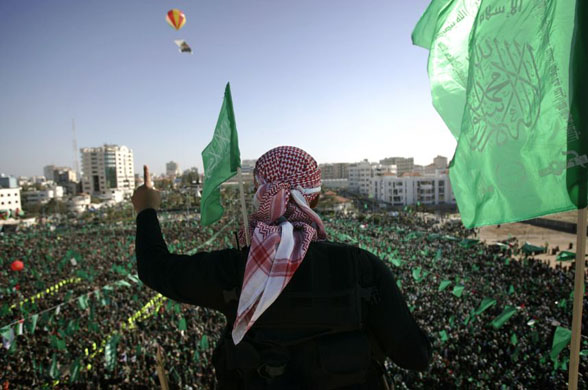 A Hamas security officer gestures, as thousands of Hamas supporters gather during a rally in Gaza
