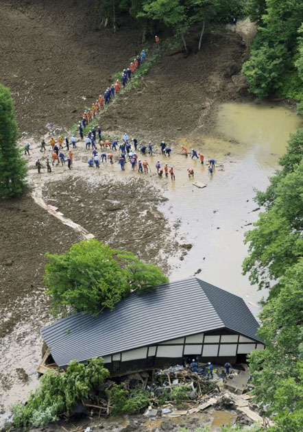Rescuers drain muddy water as part of their effort to search for survivors in Kurihara 