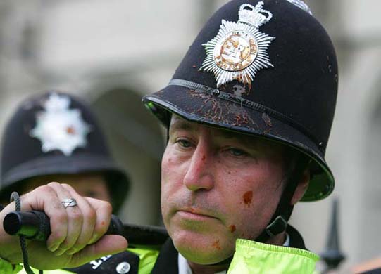 A policeman is covered in tomato sauce during a Stop the War protest in Parliament Square
