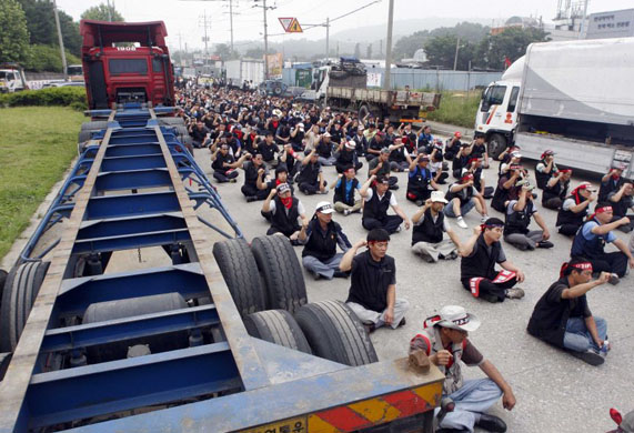 Unionised truckers chant slogans during their general strike rally in front of an Inland Container Depot terminal in Uiwang