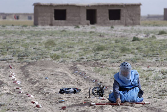 Bakhshikhail, Afghanistan: A deminer from Afghan Technical Consultants clears an area of land mines left over from conflicts involving the Taliban and mujahideen. Photograph: Farzana Wahidy/AP