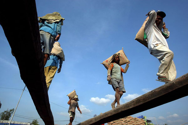 Jakarta, Indonesia: Workers carry sacks of cement before its transport to remote cities by traditional boat
