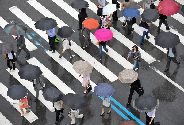 Seoul, South Korea: People carry umbrellas as they cross a street during rainy season