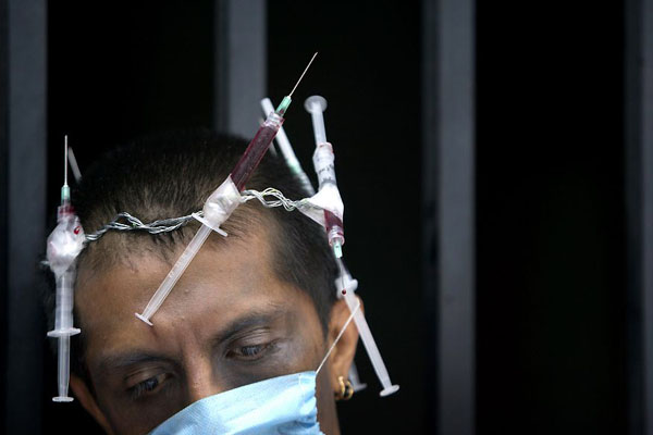 Mexico City, Mexico: Polo Gomez wears a crown of needles holding what he says is his own AIDS-infected blood during a protest against the increasing prices of AIDS medicine