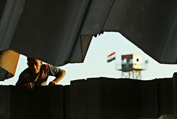Rafah, Gaza Strip: A Palestinian boy climbs on a destroyed section of the Gazan border fence separating Egypt and the southern Gaza Strip