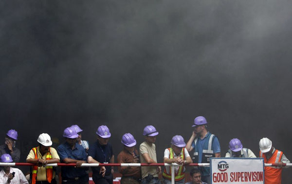 New Delhi, India: Delhi Metro Rail Corporation workers watch the tunnel boring machine