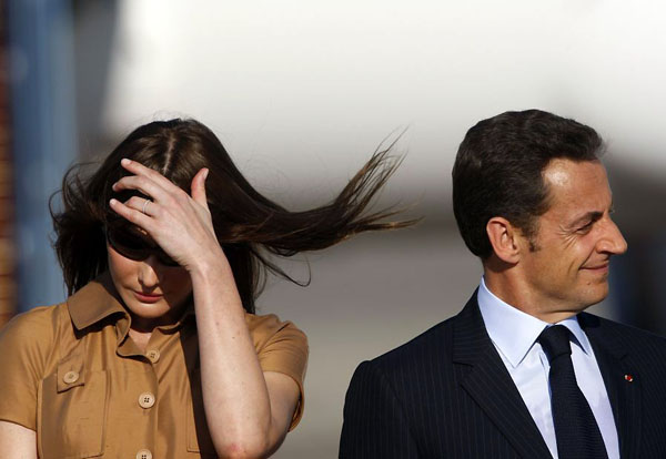 Israel: Nicolas Sarkozy listens to a speech by Simon Peres as his wife Carla Bruni-Sarkozy shades her eyes in Ben Gurion airport