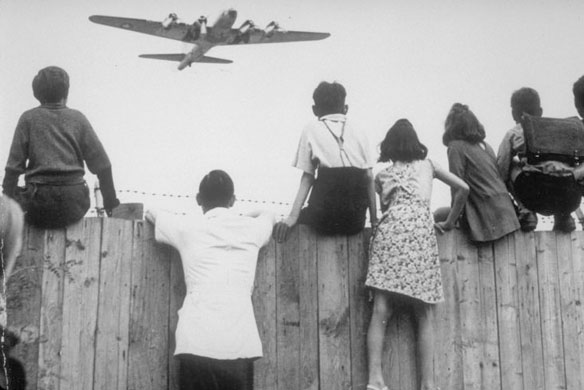 West Berlin children perched on the fence of Tempelhof airport watch the fleets of U.S. airplane