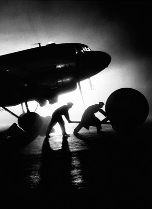 Ground crewmen load giant wheels for York transports into a Douglas DC-3 