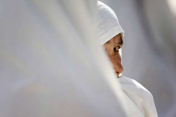 Varzaneh, Tehran: A woman wearing a white chador at a cemetery
