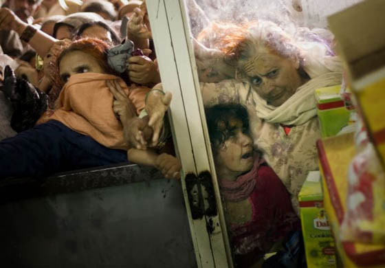 Rawalpindi, Pakistan: Women struggle as they try to order food outside a subsidized shop