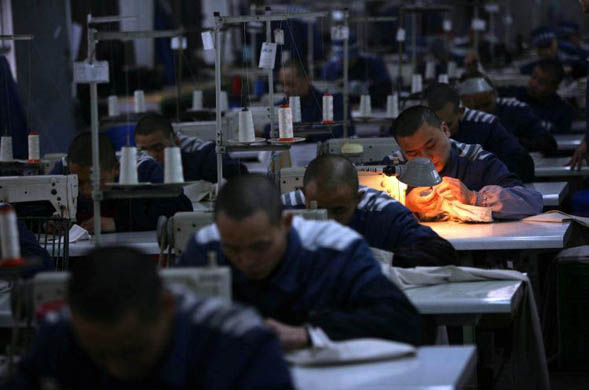 Chongqing, China: Inmates work on sewing machines at a prison