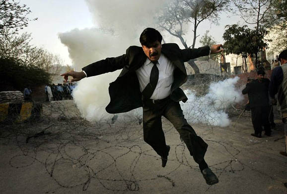 Islamabad, Pakistan: A lawyer runs away from tear gas fired by police officers 