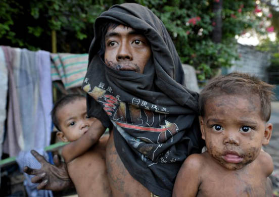 Manila, Philippines: Nelson Villamor and his sons rest on their car