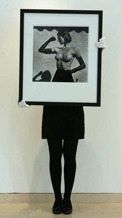 A Christies' assistant holds the photograph 'Tied up Torso, Ramatuelle, 1980' by Helmut Newton