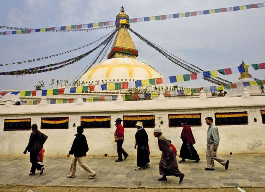 Buddhist devotees walk around the Baudhanath Stupa