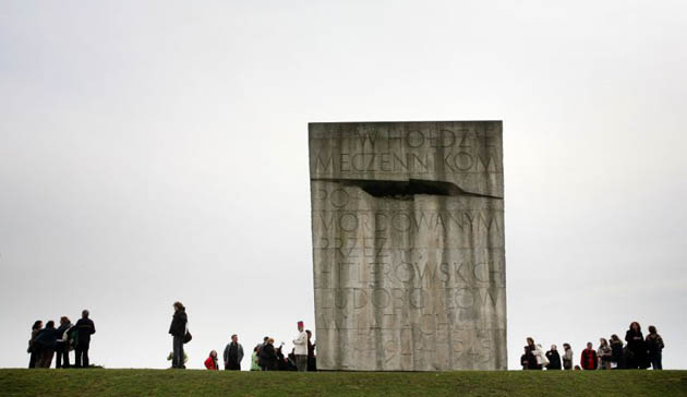  People gather around a monument commemorating the victims of the Holocaust in the former Nazi concentration camp of Plaszow
