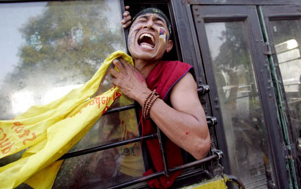 New Delhi, India: A Tibetan activist shout slogans against China as he is taken away after being detained by police