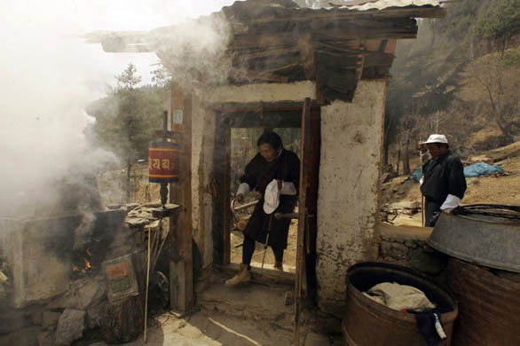 A Bhutan Peace and Prosperity Party candidate enters the courtyard of a house during an election campaign