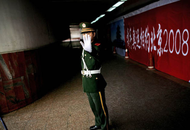 Beijing, China: A paramilitary police officer tries to prevent photos being taken under Beijing's Tiananmen Square