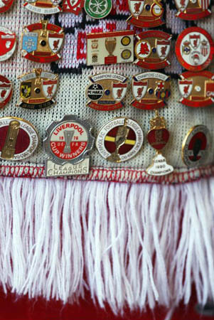 Liverpool, UK: A Liverpool fan displays his badges during the match between Liverpool and Everton at Anfield