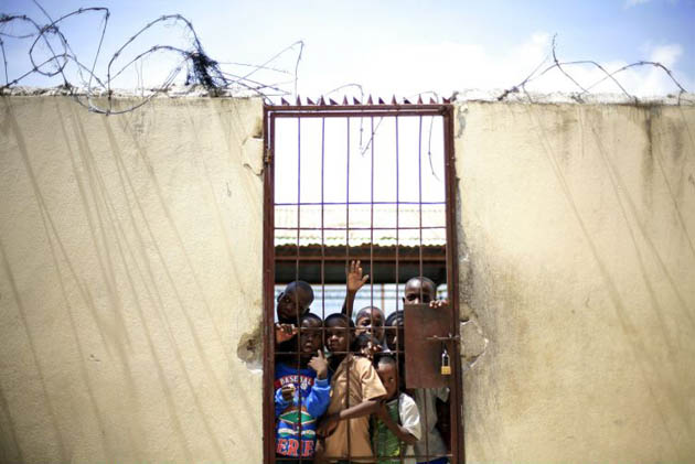 Children line up as volunteers prepare food at Saint Clare's church rectory