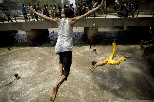 Lahore, Pakistan, young men diving into a canal
